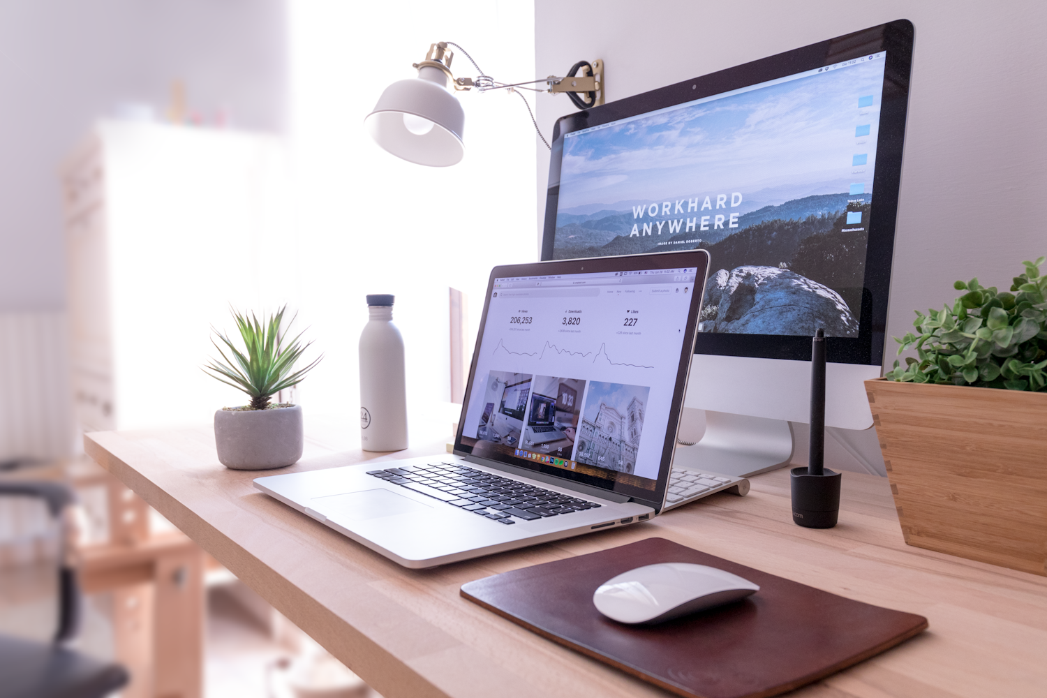 A bright creative workspace with a desktop computer and laptop